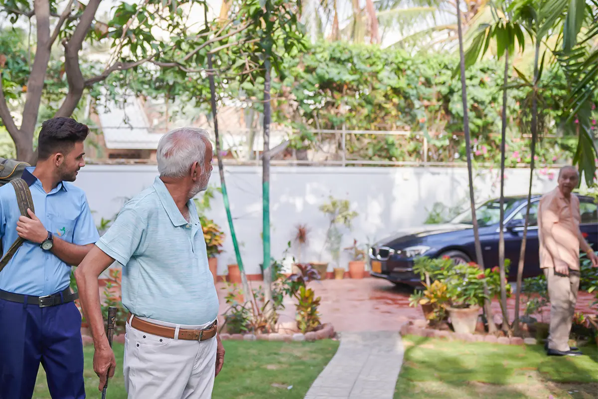 Senior man walking in the Senior Circle garden with a caregiver